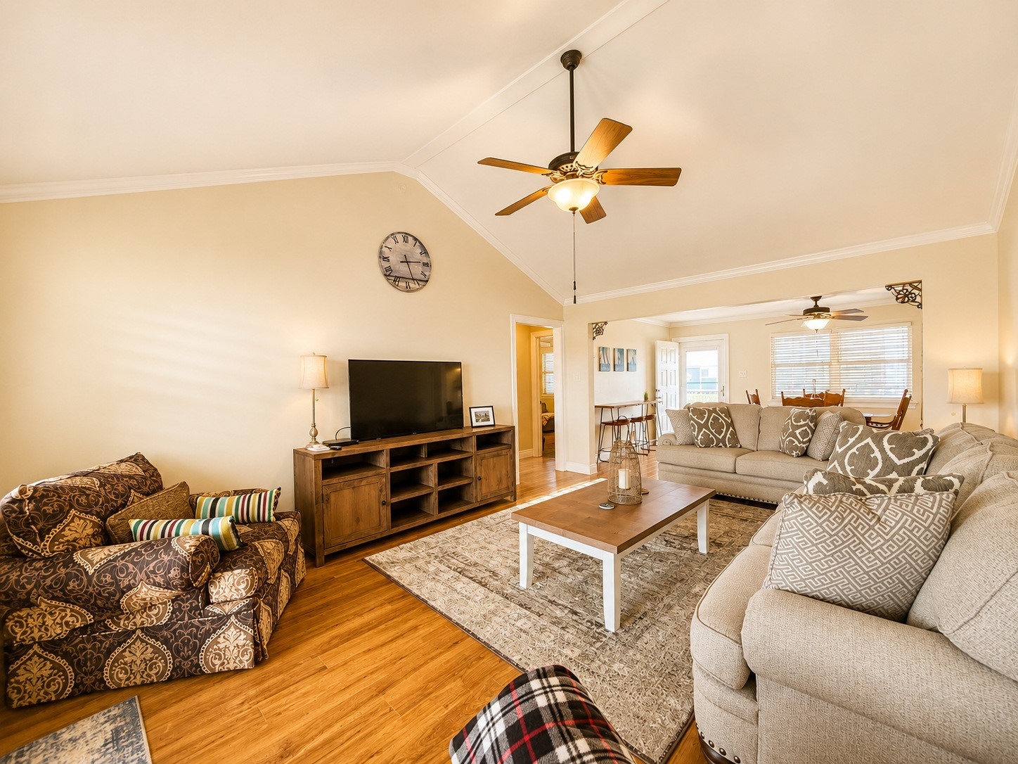 135 Sand Shoals Road Freeport, TX 77541 - Photo 11 of 20 This warm and inviting living room features high ceilings with a ceiling fan, ample natural light, and a cozy seating arrangement. The open layout seamlessly connects to the dining area, creating a spacious feel perfect for entertaining or relaxing.