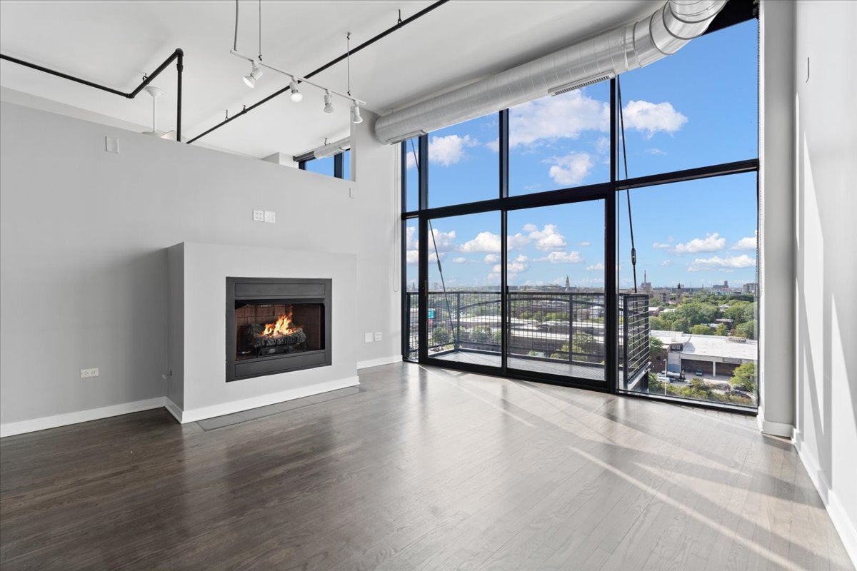 1224 West Van Buren Street, Unit 809 Chicago, IL 60607 - Photo 2 of 25 a view of an empty room with wooden floor and a window
