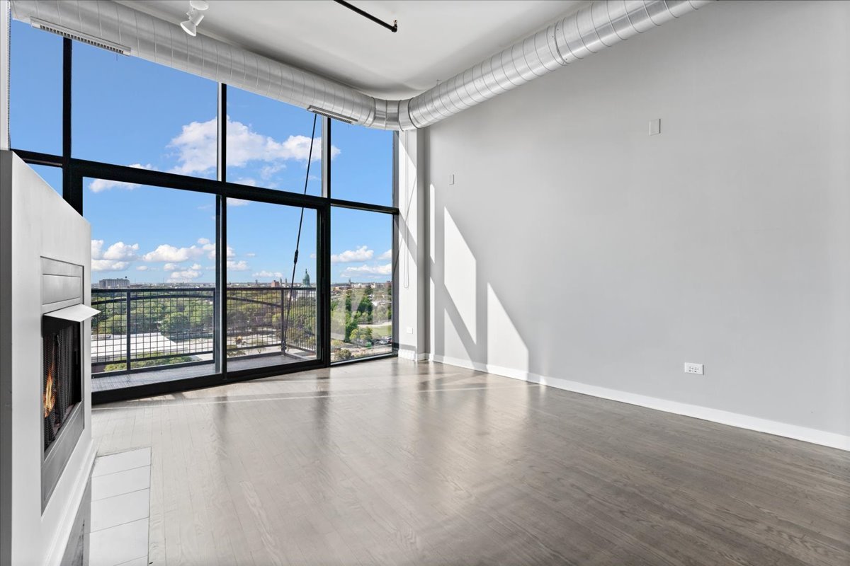 1224 West Van Buren Street, Unit 809 Chicago, IL 60607 - Photo 4 of 25 a view of an empty room with wooden floor and a window