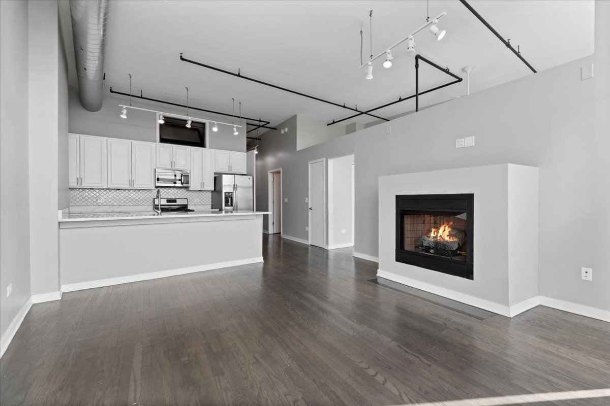 1224 West Van Buren Street, Unit 809 Chicago, IL 60607 - Photo 5 of 25 a view of a kitchen with a hallway wooden floor and a kitchen