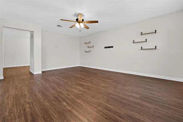 a view of empty room with wooden floor