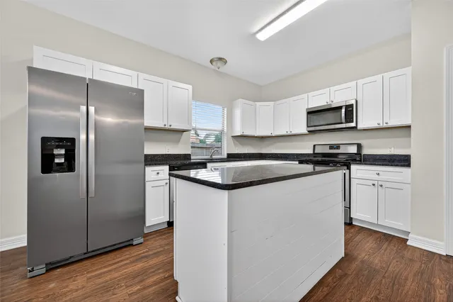 a kitchen with stainless steel appliances granite countertop a refrigerator sink and microwave