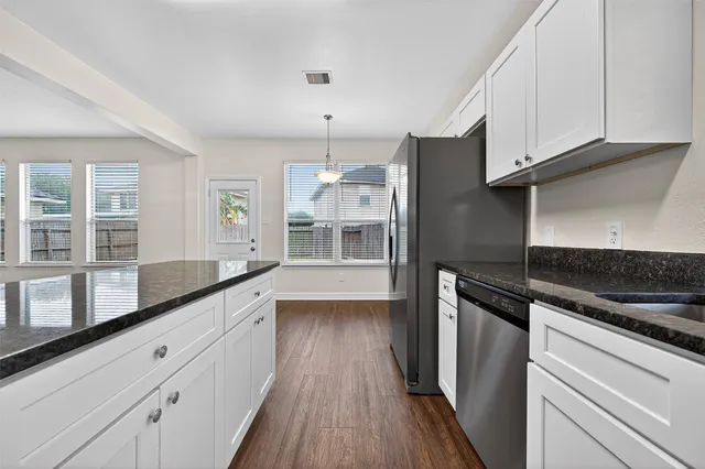 a kitchen with granite countertop a refrigerator and a stove