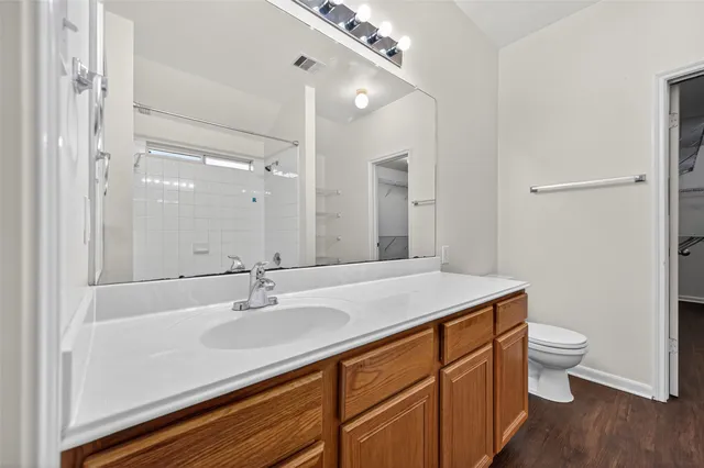 a bathroom with a granite countertop sink a toilet and a mirror