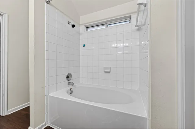 a white bath tub sitting next to a shower