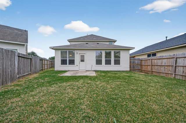 a view of a backyard with plants and wooden fence