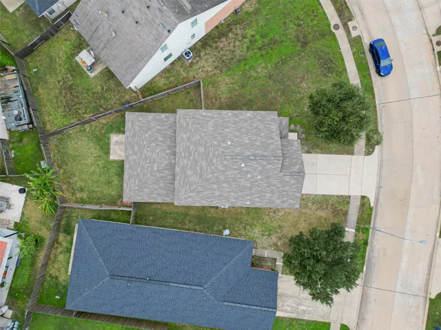 an aerial view of a house with a yard