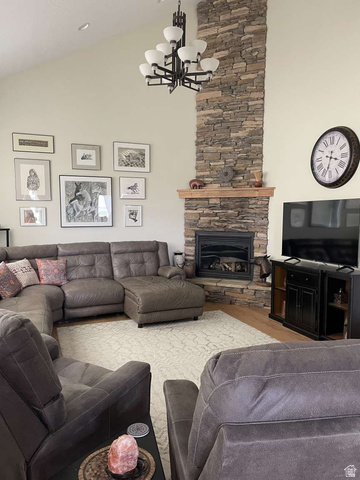 7030 West 2100 North Mendon, UT 84325 - Photo 30 of 67 Vaulted ceiling living area featuring a floor-to-ceiling stacked stone fireplace with a wood mantle