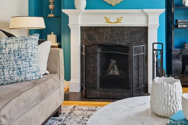 a living room with furniture a fireplace and wall paintings