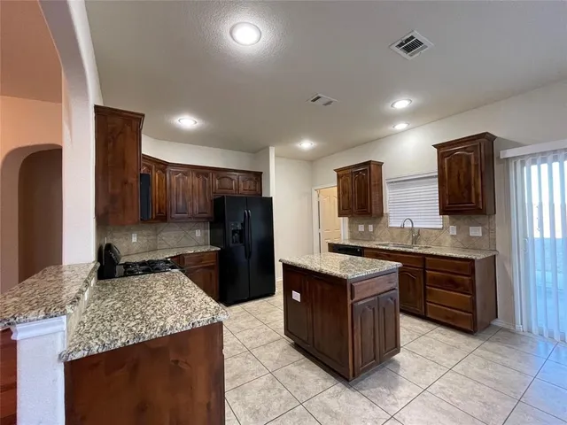 a kitchen with stainless steel appliances granite countertop a stove refrigerator and microwave