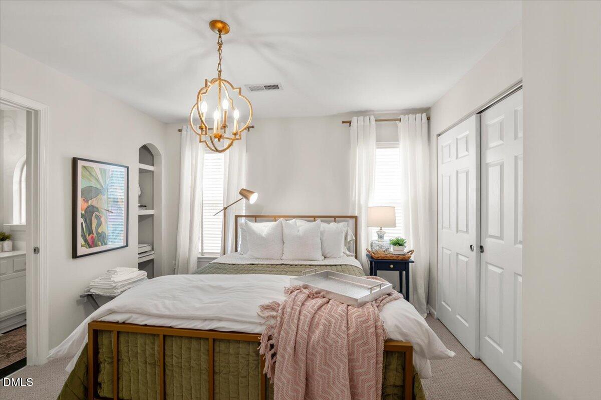 8449 Central Drive Raleigh, NC 27613 - Photo 29 of 38 a bedroom with a bed and a chandelier