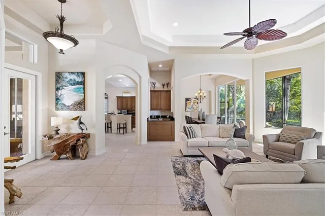 a living room with furniture a chandelier and a large window