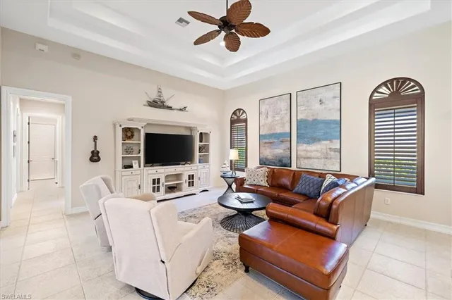 a living room with furniture ceiling fan and a flat screen tv