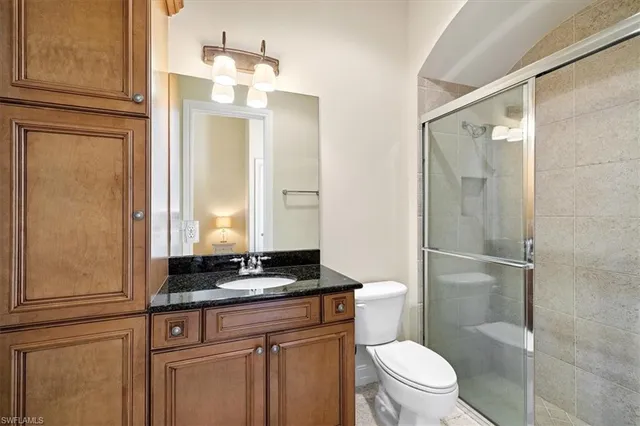 a bathroom with a granite countertop sink toilet and shower