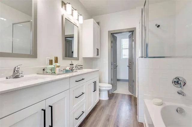 a bathroom with a sink a toilet and a large mirror