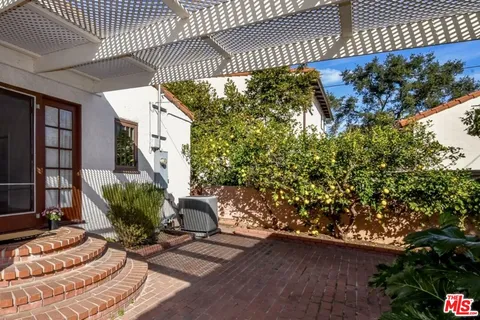 a view of backyard with seating space and trees in the background