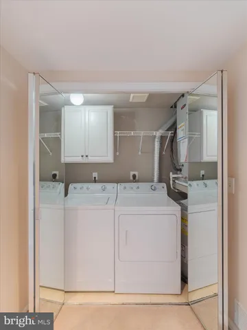 a utility room with cabinets washer and dryer