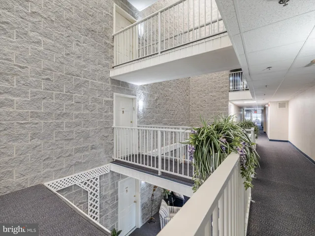 a view of staircase with railing and white walls