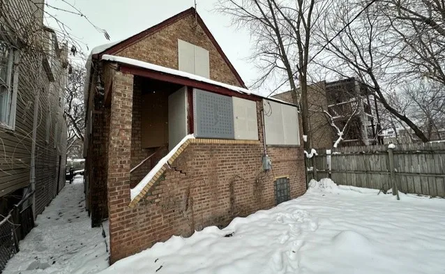 a view of a house with a wooden fence and a trees