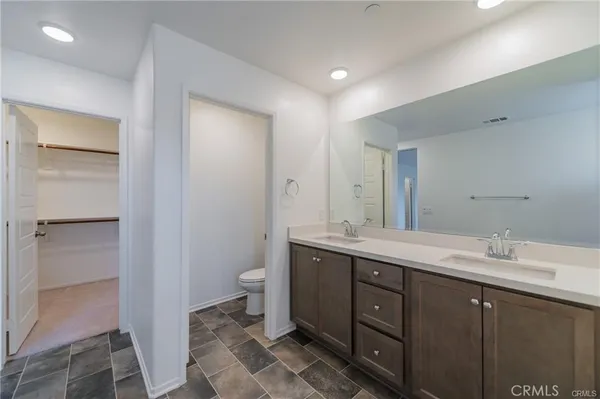 a spacious bathroom with a double vanity sink mirror and toilet