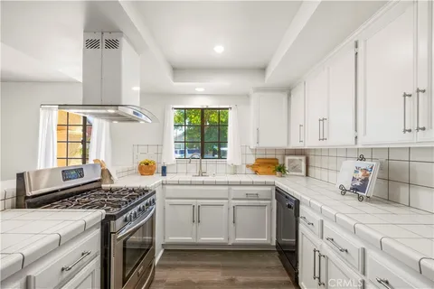 a kitchen with a stove sink and cabinets