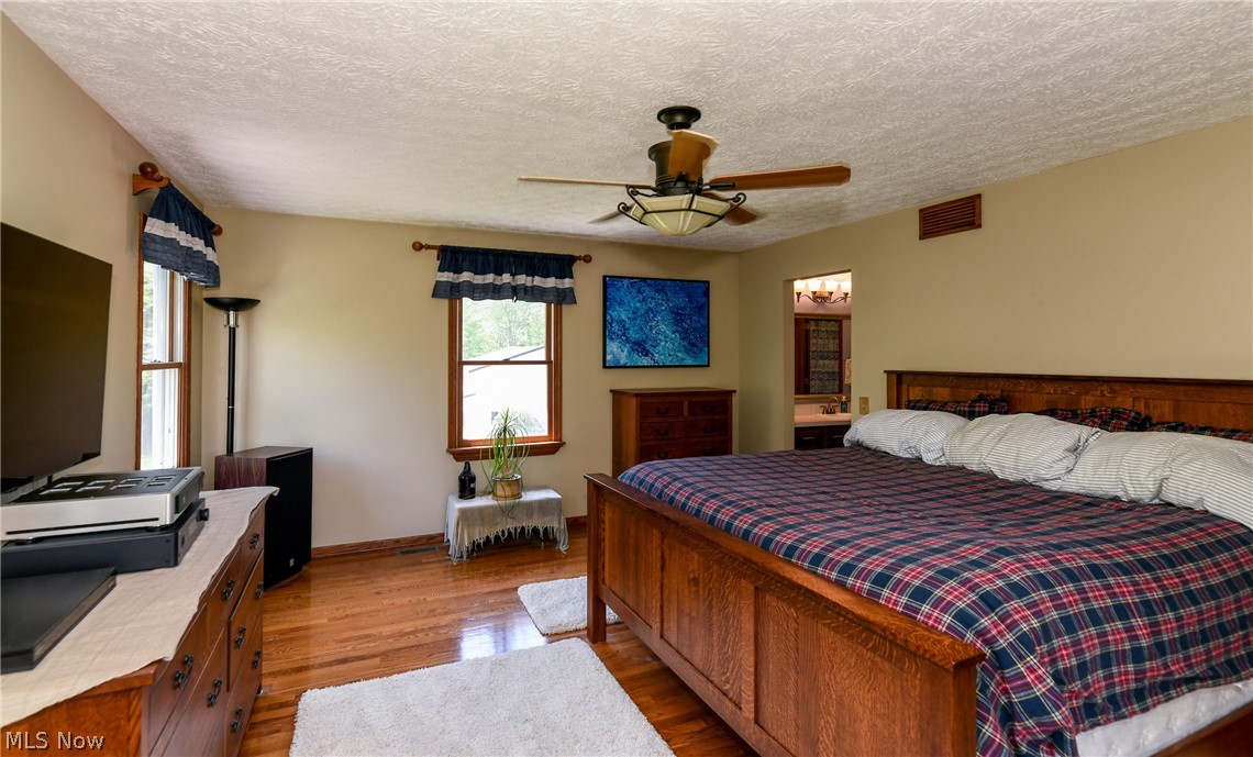 7810 Kennard Road Lodi, OH 44254 - Photo 18 of 35 Master bedroom with hardwood floors and surrounded by windows.