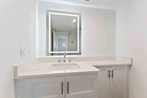 a bathroom with a sink a toilet and a mirror