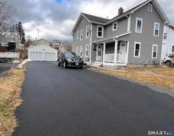 a view of a house with barbeque and sitting area