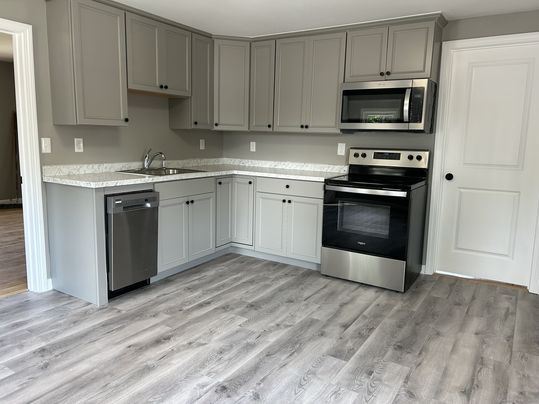 38 Beecher Street Southington, CT 06489 - Photo 3 of 12 a kitchen with stainless steel appliances a stove a microwave sink and cabinets