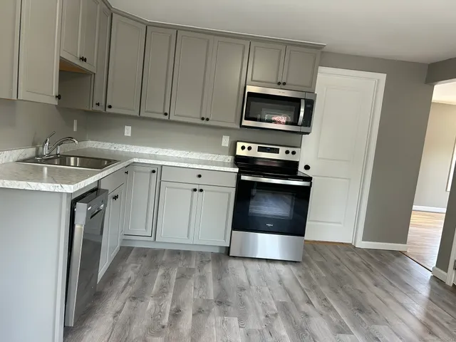 a kitchen with sink a microwave and cabinets