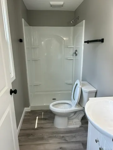a white toilet sitting next to a shower