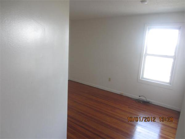 177 Nashua Street, Unit 5 Fall River, MA 02721 - Photo 11 of 15 an empty room with wooden floor and windows