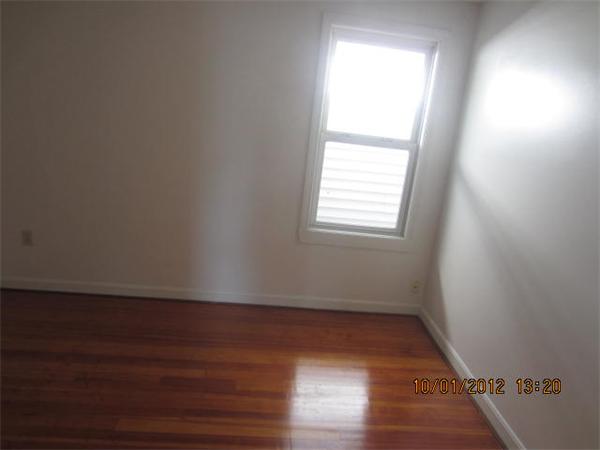 177 Nashua Street, Unit 5 Fall River, MA 02721 - Photo 13 of 15 an empty room with wooden floor and windows