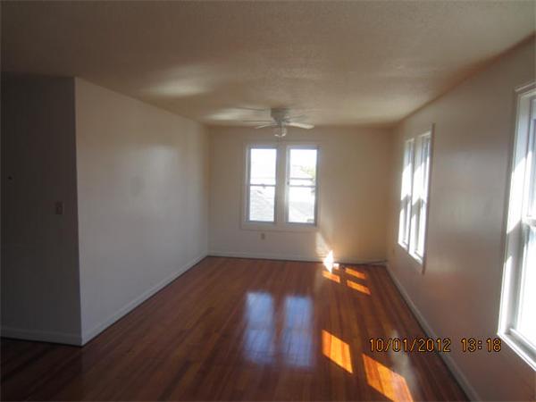 177 Nashua Street, Unit 5 Fall River, MA 02721 - Photo 4 of 15 an empty room with wooden floor and windows