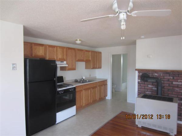 177 Nashua Street, Unit 5 Fall River, MA 02721 - Photo 6 of 15 a kitchen with granite countertop a refrigerator a stove a sink and a microwave
