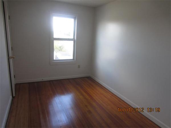 177 Nashua Street, Unit 5 Fall River, MA 02721 - Photo 9 of 15 an empty room with wooden floor and windows in it