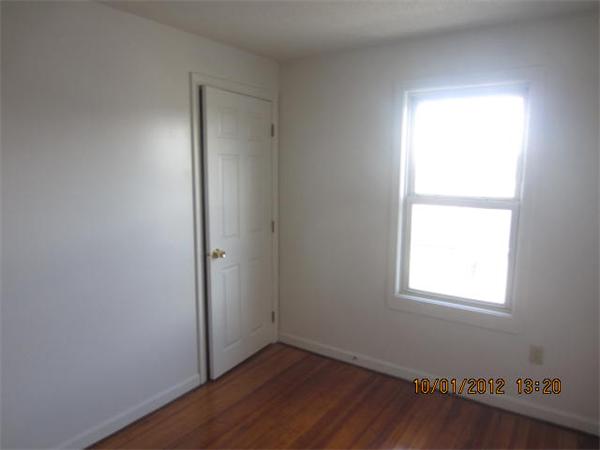 177 Nashua Street, Unit 5 Fall River, MA 02721 - Photo 10 of 15 an empty room with wooden floor and windows