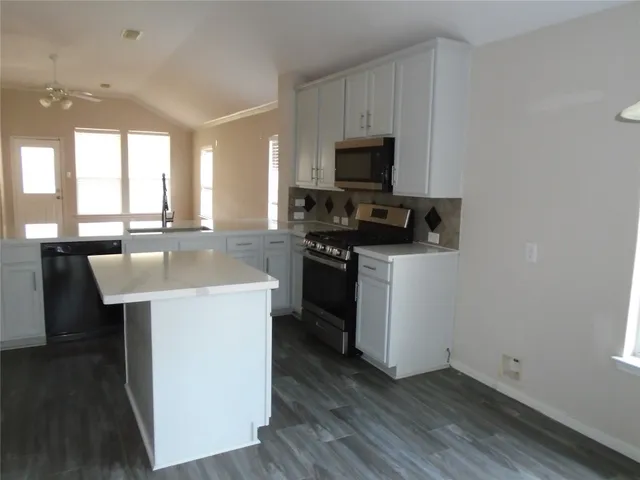 a kitchen with a sink a microwave a stove and refrigerator