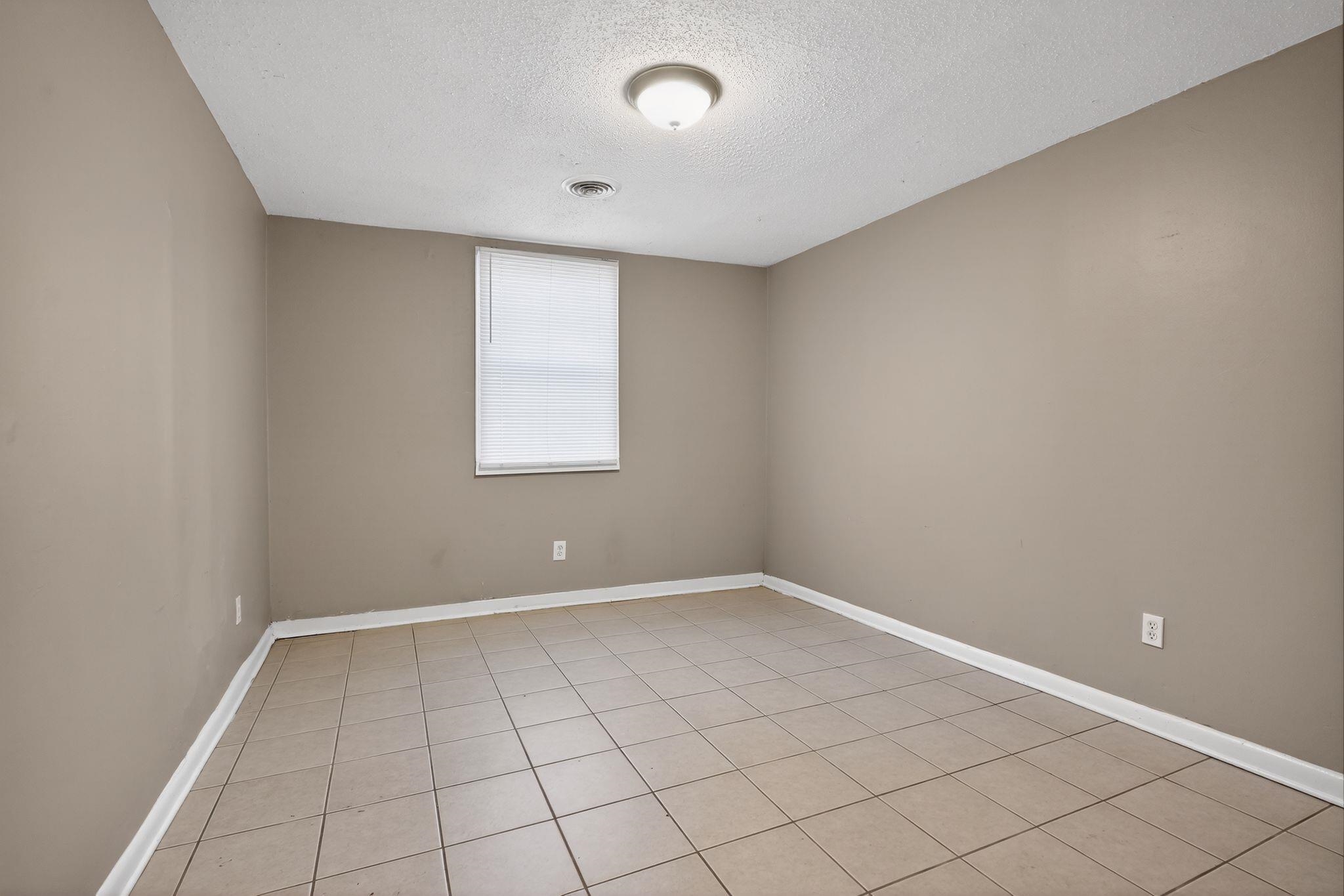 4285 Trudy Street Memphis, TN 38128 - Photo 7 of 31 Empty room featuring a textured ceiling and light tile patterned flooring