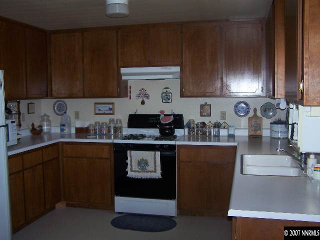 523 Yellow Jacket Road Dayton, NV 89403 - Photo 7 of 9 a kitchen with stainless steel appliances granite countertop wooden cabinets a sink and dishwasher