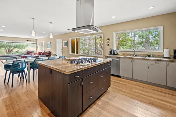 a dining room with wooden floor a chandelier a wooden table and chairs