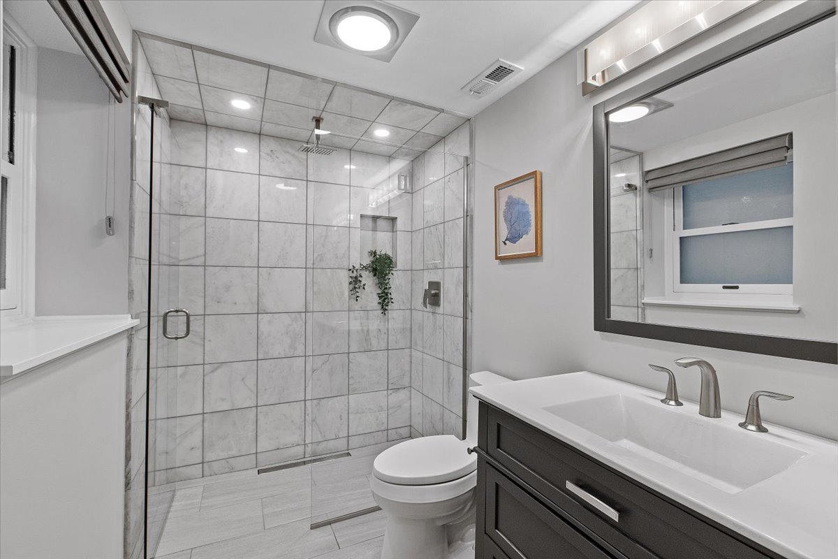 1867 North Halsted Street, Unit 1N Chicago, IL 60614 - Photo 27 of 30 a bathroom with a granite countertop toilet sink and shower