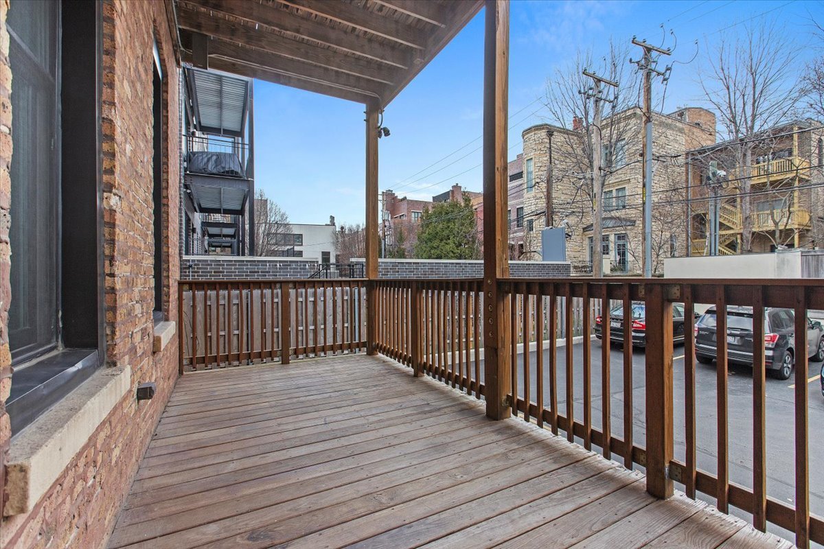 1867 North Halsted Street, Unit 1N Chicago, IL 60614 - Photo 28 of 30 a view of a balcony with wooden floor and fence