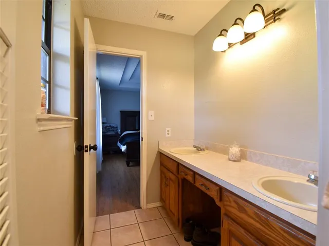 a en suite bathroom with a granite countertop sink and a mirror