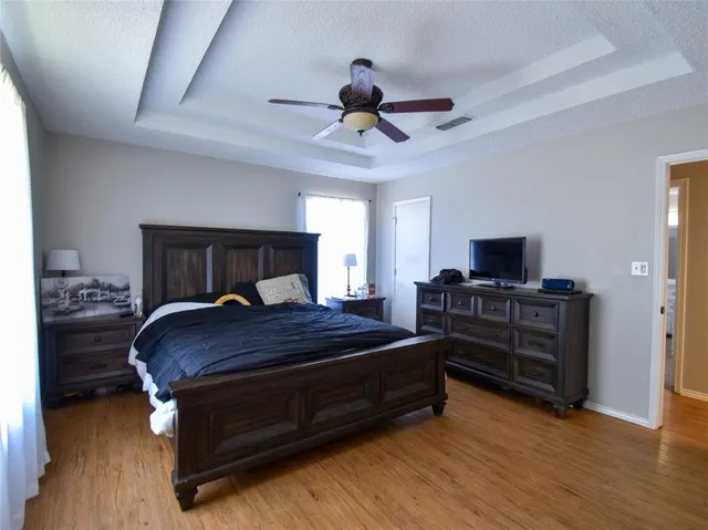 a bedroom with a bed and wooden floor