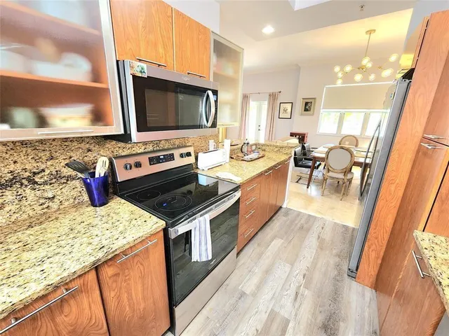 a kitchen with stainless steel appliances granite countertop a stove and a wooden floors