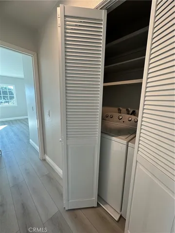 a view of a hallway with wooden floor and stairs