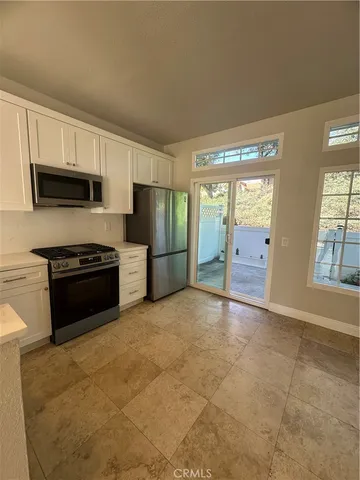 a view of kitchen with granite countertop a stove top oven a sink and a refrigerator