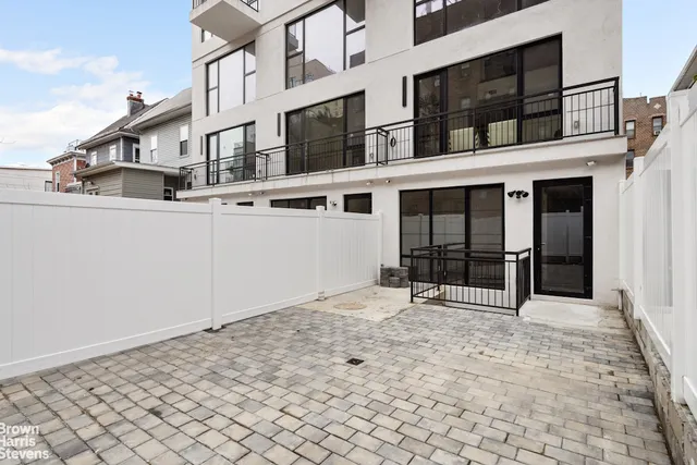 a front view of a building with lot of cars and trees