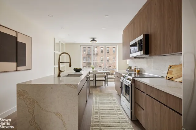 a kitchen with a stove a sink and a wooden cabinets